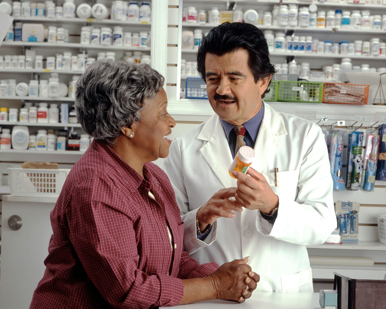 Pharmacien conseillant une patiente au comptoir de la pharmacie interne